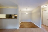 This single-floor residence offers a thoughtfully designed layout that balances comfort and functionality throughout. The open-concept living and dining area serves as the heart of the home, where warm neutral walls and plush carpeting in the living space transition seamlessly to rich hardwood-style flooring in the dining area. A pendant light fixture adds a refined focal point above the dining space, which connects directly to the kitchen via a convenient pass-through counter. The kitchen is well-equipped with dark cabinetry, granite-style countertops, black appliances including a refrigerator and electric range, and durable hardwood-style flooring — providing both style and practicality. The primary bedroom is generously proportioned, featuring soft carpeting, neutral tones, and access to an en-suite bathroom with a shower-tub combination. Additional bedrooms are comfortably sized, each with carpet flooring, natural light from windows fitted with horizontal blinds, and six-panel doors. A dedicated bathroom with hardwood-style flooring and a full tub-shower unit serves the remaining rooms. The living area benefits from French-style doors that open to a private balcony, inviting natural light and outdoor views into the space. Textured ceilings and clean white baseboards throughout lend a cohesive, well-maintained character to the entire residence.