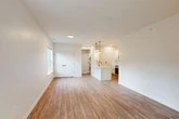 Located at 1061 Dryden Rd in Ithaca, NY, this two-story home offers a clean, modern aesthetic with thoughtful design throughout. The main living level hosts a bright, open-concept space that seamlessly integrates the living room, dining area, and kitchen. Light wood-tone flooring runs throughout, complementing the crisp white walls and abundant natural light from well-placed windows. The kitchen is a standout feature, boasting white shaker cabinetry, a white quartz peninsula with a matte black sink, stainless steel appliances including a range, microwave, and refrigerator, and elegant pendant lighting overhead. A subway tile backsplash adds a refined finishing touch. Ample closet storage is distributed throughout the home, with six closets in total. The two bedrooms are comfortably sized, with the primary bedroom featuring plush carpet, a ceiling fan, large windows with garden views, and direct access to a full bathroom. The bathrooms are finished with modern matte black fixtures, including a glass-enclosed walk-in shower. A private balcony off the upper level offers serene views of mature evergreen trees and landscaped grounds. The attached garage on the ground level provides convenient covered parking and additional storage space.