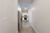 Located in Austin, TX 78745, this modern single-story unit offers 2 bedrooms and 2 bathrooms across a well-designed layout. Polished concrete floors run throughout, lending a sleek, contemporary aesthetic to every room. The kitchen is outfitted with white shaker cabinetry, a subway tile backsplash, and a full suite of stainless steel appliances including a French door refrigerator, electric range, and over-the-range microwave. The living area is a standout feature, boasting expansive floor-to-ceiling windows framed in black that invite abundant natural light and provide open views of the surrounding landscape. The generously sized primary bedroom includes high transom windows that allow for additional natural light while maintaining privacy. The second bedroom is clean and bright with crisp white walls and polished concrete flooring. Both bathrooms reflect the home's modern design, with one featuring a white vanity topped with granite countertop, a large mirror, and a clean, minimal layout. Throughout the unit, white walls and clean lines create a bright, open atmosphere that is both functional and contemporary in style.