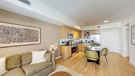 Located at 922 E 26th St in Hialeah, Florida, this thoughtfully designed 2-bedroom, 1-bathroom residence offers a modern open-concept layout that maximizes every inch of its well-appointed floor plan. Light wood flooring flows throughout, creating a warm and cohesive aesthetic across all living areas.

The combined kitchen and living room serves as the heart of the home. The kitchen is outfitted with sleek wood cabinetry, dark countertops, a full suite of stainless steel appliances including a range, dishwasher, microwave, and refrigerator, and a tile backsplash. A dining area with seating for four sits adjacent, creating a seamless space for cooking and entertaining. The living room opens to a private balcony through floor-to-ceiling sliding glass doors, flooding the space with natural light and offering views of the surrounding cityscape.

Both bedrooms feature light wood flooring, large windows with urban views, and access to a dedicated closet. The primary bedroom is a comfortable retreat with ample room for full furnishings.

The bathroom is finished in a crisp black-and-white palette, featuring large-format gray floor tile, a wood-toned vanity with dark countertop, and a shower-tub combination. A hallway connects all rooms efficiently, completing this well-organized and stylishly modern Hialeah residence.