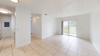 Located in Florida City, FL, this single-floor residence offers four bedrooms, one bathroom, a kitchen, a closet, and a hallway — providing a practical and well-organized layout. Throughout the bedrooms, light wood-look laminate flooring and crisp white walls create a clean, bright atmosphere, while textured ceilings add a classic touch. Each bedroom benefits from natural light streaming through window blinds, with several rooms offering views of the surrounding neighborhood greenery. One bedroom features a sliding closet for convenient storage.

The galley-style kitchen is efficiently designed with warm honey-toned wood cabinetry lining both walls, light countertops, a stainless steel sink, and white appliances including a range and refrigerator — maximizing storage and functionality within a compact footprint.

The shared bathroom is finished with a tiled tub-shower combination, a wood-vanity with a white countertop, and the same light flooring found throughout the unit, maintaining a cohesive aesthetic.

The living and entry areas feature light ceramic tile flooring and are filled with natural light, highlighted by a sliding glass door that opens directly to an outdoor grassy area — extending the sense of space and providing a seamless indoor-outdoor connection.