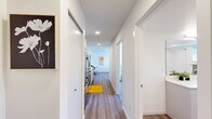 Located at 4221 37th Ave S in Seattle's vibrant Columbia City neighborhood, this thoughtfully designed one-bedroom, one-bathroom residence offers a bright and contemporary living experience across a generously sized single floor. The open-concept layout is anchored by a sun-drenched living room featuring large sliding glass doors that flood the space with natural light and provide direct access to a spacious private balcony. The balcony offers sweeping views of the surrounding tree-lined neighborhood and serves as an ideal outdoor retreat. Wide-plank hardwood-style flooring runs throughout, lending warmth and cohesion to every room. The kitchen is efficiently positioned along the corridor, outfitted with stainless steel appliances and modern cabinetry. The bedroom is a tranquil retreat with a sliding closet and its own access to the balcony, complemented by an additional dedicated closet for ample storage. The full bathroom is sleekly appointed with a long white vanity, a large mirror, and in-unit stacked washer and dryer. A wall-mounted mini-split system provides year-round climate control. Clean white walls, recessed lighting, and a crisp modern aesthetic define the overall ambiance of this well-appointed urban residence.