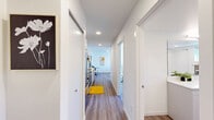 Located at 4221 37th Ave S in Seattle's vibrant Columbia City neighborhood, this thoughtfully designed one-bedroom, one-bathroom residence offers a bright and contemporary living experience across a generously sized single floor. The open-concept layout is anchored by a sun-drenched living room featuring large sliding glass doors that flood the space with natural light and provide direct access to a spacious private balcony. The balcony offers sweeping views of the surrounding tree-lined neighborhood and serves as an ideal outdoor retreat. Wide-plank hardwood-style flooring runs throughout, lending warmth and cohesion to every room. The kitchen is efficiently positioned along the corridor, outfitted with stainless steel appliances and modern cabinetry. The bedroom is a tranquil retreat with a sliding closet and its own access to the balcony, complemented by an additional dedicated closet for ample storage. The full bathroom is sleekly appointed with a long white vanity, a large mirror, and in-unit stacked washer and dryer. A wall-mounted mini-split system provides year-round climate control. Clean white walls, recessed lighting, and a crisp modern aesthetic define the overall ambiance of this well-appointed urban residence.