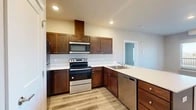 Located at 821 N Stanley St in Medical Lake, WA, this thoughtfully designed one-bedroom, three-bathroom unit delivers a clean, modern aesthetic across a single-floor layout. Light-toned luxury vinyl plank flooring flows consistently throughout, creating a cohesive and easy-to-maintain living environment.

The kitchen is a standout feature, showcasing rich dark-stained wood cabinetry, crisp white countertops, and a full suite of stainless steel appliances including a range, microwave, dishwasher, and refrigerator. An L-shaped peninsula with an undermount sink provides additional workspace and casual seating, opening naturally toward the living area.

The living room is bright and open, benefiting from recessed lighting and a private exterior door with windows that invite natural light. A wall-mounted HVAC unit ensures year-round comfort.

The primary bedroom offers a comfortable footprint with a window framing outdoor views, recessed lighting, and access to an adjacent closet. The bathrooms are finished with warm wood-toned cabinetry, white countertops, large mirrors, and tub-shower combinations with clean white surrounds.

Neutral wall tones and consistent trim work lend a fresh, move-in-ready feel throughout this well-appointed Medical Lake residence.