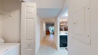 Located at 380 Brazilian Cir in Port Saint Lucie, FL, this well-appointed 2-bedroom, 2-bathroom single-story home offers a thoughtfully designed layout ideal for comfortable Florida living. The open-concept kitchen connects seamlessly to the dining and living areas via a pass-through counter, creating an inviting, communal atmosphere. The kitchen features white cabinetry, light countertops, a double sink, and a dishwasher. A chandelier overhead adds a warm ambiance to the dining area, which is finished with light tile flooring that extends throughout the main living spaces. The living room is bright and airy, with a sliding glass door that opens to a covered screened patio — perfect for outdoor dining amid the lush, tree-lined surroundings. The spacious primary bedroom is carpeted, fitted with a ceiling fan, and benefits from a natural window view of the greenery outside. It includes a generous walk-in closet with wire shelving. The second bedroom offers built-in closet storage and plush carpeting. Both bathrooms are finished in light tile, with the full bath featuring a glass-enclosed shower-tub combo, vanity, and a window for natural light. Hallways connect the spaces efficiently, completing this clean and functional Florida residence.