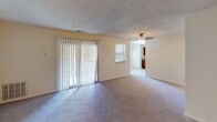 Located at 51 Valley Park S in Bethlehem, Pennsylvania, this single-floor residence offers a straightforward and functional layout designed for comfortable everyday living. The living area is generously sized, featuring neutral-toned wall-to-wall carpeting, a textured ceiling, and a ceiling fan. A large sliding glass door fitted with vertical blinds allows natural light to fill the space and provides access to the outdoors. An additional window further brightens the room, contributing to an open and airy ambiance.

The kitchen is well-appointed with rich, warm-toned wood cabinetry extending to the upper walls, offering substantial storage. Granite-look countertops provide a clean work surface, complemented by a stainless steel sink, a built-in dishwasher, and a refrigerator. The layout is efficient, making practical use of the available space.

The bedrooms feature plush carpeting and neutral walls, with one room offering a double closet and another benefiting from a window with an exterior view. Both rooms provide a calm, functional setting.

The bathrooms are finished with cream-toned square wall tiles surrounding the tub-shower combinations, with standard fixtures throughout. A wall-mounted mirror adds utility to one of the bathrooms.

A staircase is visible in the floor plan model, suggesting access to a lower level. Overall, the space presents a clean, neutral palette throughout.