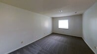 Located at 425 Waupelani Drive in State College, Pennsylvania, this single-floor apartment offers 870 square feet of living space across two bedrooms, one bathroom, and a connecting hallway. The layout is straightforward and functional, with rooms connected via a central hallway visible in the floor plan.

Both bedrooms feature wall-to-wall dark carpeting and neutral white walls, providing a clean, move-in-ready canvas. The primary bedroom measures a spacious 190 square feet and includes a double-door closet, a wall sconce, and access to the hallway. A window allows for natural light. The second bedroom also features carpet flooring, a ceiling light fixture, a baseboard heater, and its own window that brings in additional natural light.

The bathroom is equipped with a full tub and shower combination, finished with classic white square tile surround reaching the ceiling, and chrome fixtures. The hallway connects all rooms efficiently, with hardwood-style flooring visible in transitional areas. Ceiling vents indicate central air distribution throughout the unit. The overall ambiance is simple, clean, and practical, making this apartment a solid option for those seeking straightforward accommodations in State College.