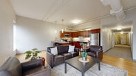 Located at 2599 Church Ave in Cleveland, OH, this three-bedroom, two-bathroom unit offers a thoughtfully designed single-floor layout. The open-concept living and kitchen area is the heart of the home, featuring soaring ceilings with exposed ductwork that lend an urban, loft-inspired character. Large windows flood the living room with natural light and provide views of the surrounding cityscape, while light bamboo hardwood flooring ties the space together seamlessly. The kitchen is well-appointed with rich cherry wood cabinetry, granite countertops, stainless steel appliances including a refrigerator, microwave, dishwasher, and range, and a peninsula with bar seating illuminated by pendant lighting — ideal for casual dining or entertaining. The three bedrooms are carpeted for comfort, each offering closet space with built-in shelving and rods. The spacious primary bedroom provides ample room and direct closet access. Two full bathrooms include vanities with granite countertops and walk-in shower stalls. A dedicated laundry area houses a stacked washer and dryer unit, adding everyday convenience. A programmable thermostat ensures climate control throughout the home.