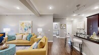 This single-story unit in Conway, Arkansas, offers a thoughtfully designed layout encompassing a living room, kitchen, bedroom, and bathroom. Crown molding, wood-style flooring, and recessed lighting are consistent throughout, lending a cohesive, polished aesthetic.

The living room serves as the heart of the space, featuring a fireplace with a granite surround, a ceiling fan, and access to an exterior door with wood-slatted blinds. The open sightlines connect the living area to the kitchen, which is outfitted with rich dark-wood cabinetry reaching to the ceiling, dark granite countertops, a white subway tile backsplash, stainless steel appliances, and a peninsula with bar seating—ideal for casual dining.

The bedroom is generously proportioned, offering a ceiling fan, a window with natural light, and a wide double-door closet with built-in shelving. Crown molding continues here, maintaining the refined character of the unit.

The bathroom features a soaking tub with full tile surround, a glass panel enclosure, dark wood cabinetry with a dark countertop, and wood-style flooring accented by marble-patterned rugs, creating a spa-like atmosphere.