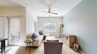 Located at 7606 W Peoria Ave in Peoria, Arizona, this single-floor, 2-bedroom, 2-bathroom residence offers a comfortable and efficiently designed layout. The living room is a welcoming space highlighted by soaring ceilings, a ceiling fan, large windows that invite abundant natural light, and a soothing neutral color palette with a soft blue accent wall. Plush carpet and generous proportions make it ideal for relaxing or entertaining.

The kitchen features warm wood-toned cabinetry, dark countertops, and black appliances including an electric range and built-in microwave, all set atop wood-look flooring for easy maintenance.

The primary bedroom is a restful retreat, distinguished by a bold teal accent wall, a ceiling fan, a large window with outdoor views, and a spacious walk-in closet with ample shelving and hanging rods. The second bedroom is bright and airy, with neutral white walls, plush carpeting, and a large window that fills the room with natural light.

Both bathrooms offer consistent finishes, including wood-look flooring, wood-toned vanities with dark countertops, and full shower-tub combinations. A connecting hallway and two closets round out the thoughtful floor plan, providing practical storage throughout.