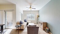 Located at 7606 W Peoria Ave in Peoria, Arizona, this single-floor, 2-bedroom, 2-bathroom residence offers a comfortable and efficiently designed layout. The living room is a welcoming space highlighted by soaring ceilings, a ceiling fan, large windows that invite abundant natural light, and a soothing neutral color palette with a soft blue accent wall. Plush carpet and generous proportions make it ideal for relaxing or entertaining.

The kitchen features warm wood-toned cabinetry, dark countertops, and black appliances including an electric range and built-in microwave, all set atop wood-look flooring for easy maintenance.

The primary bedroom is a restful retreat, distinguished by a bold teal accent wall, a ceiling fan, a large window with outdoor views, and a spacious walk-in closet with ample shelving and hanging rods. The second bedroom is bright and airy, with neutral white walls, plush carpeting, and a large window that fills the room with natural light.

Both bathrooms offer consistent finishes, including wood-look flooring, wood-toned vanities with dark countertops, and full shower-tub combinations. A connecting hallway and two closets round out the thoughtful floor plan, providing practical storage throughout.