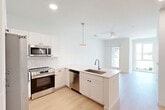 Located at 600 St Clair Ave SW in Huntsville, Alabama, this contemporary two-story residence offers three bedrooms and four bathrooms thoughtfully distributed across two well-proportioned floors. The main level centers on an open-concept living and kitchen area flooded with natural light. The kitchen is outfitted with crisp white shaker cabinetry, a subway tile backsplash, stainless steel appliances including a side-by-side refrigerator, electric range, built-in microwave, and dishwasher, all anchored by a peninsula with a undermount sink and light quartz countertops. Light wood-tone flooring flows seamlessly throughout both levels, complementing the clean white walls and modern aesthetic. A ceiling fan and recessed lighting enhance the living area's comfort and brightness. The upper floor houses the bedrooms, including a primary suite with an en-suite bathroom featuring illuminated vanity mirrors and ample cabinetry. Additional bathrooms are finished with tiled tub-shower combinations, light countertops, and wood-look flooring. Secondary bedrooms benefit from large windows that invite natural light and outdoor views of the surrounding neighborhood. Two staircases provide convenient circulation between floors, while dedicated closets and a hallway round out the efficient, well-designed layout. The overall ambiance is clean, bright, and move-in ready.