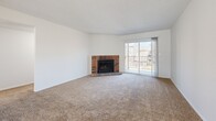 Located at 5020 Glenwood St in Mission, Kansas, this 2-bedroom, 3-bathroom residence offers a well-organized single-floor layout designed for comfortable everyday living. The spacious living room serves as the heart of the home, highlighted by a classic brick wood-burning fireplace and a sliding glass door that opens to a private balcony, allowing natural light to fill the room. Plush carpeting flows throughout the living and bedroom areas, adding warmth underfoot. The kitchen is equipped with warm wood cabinetry, light countertops, tile flooring, black appliances including a range, microwave, and dishwasher, and a stainless steel refrigerator. A pass-through counter connects the kitchen to the adjacent dining area, which is brightened by a pair of windows. The primary bedroom is generously sized and features a built-in closet along with direct access to a private en-suite bathroom. The en-suite includes a long vanity with wood cabinetry and dual mirrors. A second well-proportioned bedroom also provides closet storage. The three bathrooms include tub-shower combinations with clean white tile surround. A hallway and dedicated closet space round out this efficiently designed residence.