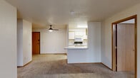 Located at 5100 S Nevada Ave in Sioux Falls, South Dakota, this 2-bedroom, 3-bathroom residence offers a well-organized single-floor layout designed for comfortable everyday living. The open-concept living and dining area features plush wall-to-wall carpeting, a ceiling fan, and a textured ceiling, creating a warm and inviting atmosphere. A sliding glass door leads to a private balcony, filling the space with natural light and providing outdoor access. The kitchen is positioned adjacent to the living area, separated by a convenient breakfast bar. It features white cabinetry with warm wood trim accents, a double stainless steel sink, tile-style flooring, and a full suite of appliances including a refrigerator, range, microwave, and dishwasher. Both bedrooms are carpeted and well-lit, with the primary bedroom offering generous proportions and ample closet space. The bathrooms are finished with tile-style flooring and include full tub-and-shower combinations with white vanities. A dedicated closet with wire shelving adds additional storage. An in-unit laundry area rounds out the functional layout. Warm wood-tone door frames and trim are consistent throughout, tying together the overall aesthetic of the space.