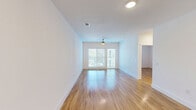 Located at 6306 McNeil Dr in Austin, TX, this single-story, one-bedroom, one-bathroom unit offers a clean, modern aesthetic with a thoughtfully designed layout. Light-toned hardwood-style flooring runs throughout the entire space, creating a cohesive and bright atmosphere.

The open living area is a standout feature, bathed in natural light from large sliding glass doors that open to a balcony view, complemented by a ceiling fan overhead. The entry area is clean and minimalist, with recessed lighting and crisp white walls setting a contemporary tone.

The galley-style kitchen is well-appointed with white shaker cabinetry featuring brushed nickel hardware, gray quartz countertops, a stainless steel sink, and a bold dark tile backsplash. Stainless steel appliances — including a refrigerator, range, microwave, and dishwasher — complete the functional cooking space.

The bedroom is a quiet, comfortable retreat with neutral white walls and ample room for furnishings. The bathroom features a glass-enclosed walk-in shower with classic white subway tile, a built-in grab bar, a toilet, and white wall-mounted cabinetry with brushed nickel hardware. Recessed lighting provides a clean, modern finish throughout the unit.