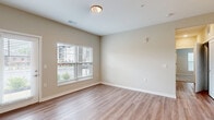 Located at 5164 Central College Rd. in Westerville, Ohio, this well-appointed two-bedroom, one-bathroom residence offers a thoughtfully designed single-floor layout. The open-concept living, dining, and kitchen area serves as the heart of the home, featuring light wood-look flooring, neutral warm-toned walls, and abundant natural light streaming through large windows. A sliding glass door leads directly to a private patio, enhancing the sense of indoor-outdoor connectivity. The modern kitchen is equipped with stainless steel appliances—including a full-size refrigerator, electric range, and microwave—complemented by sleek gray cabinetry, a white quartz-style countertop, subway tile backsplash, and a center island with a sink. Both bedrooms are finished with plush carpeting and large windows that bring in natural light. The primary bedroom features a spacious walk-in closet with wire shelving, while additional closets provide generous storage throughout. The full bathroom includes a soaking tub and shower combo with chrome fixtures and wood-look flooring. Completing the unit are a dedicated laundry area and a utility room, making this a fully functional and comfortable living space.