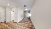 Located at 25 Lowell St in Manchester, NH, this efficiently designed studio offers a thoughtfully planned single-floor layout that maximizes every square foot. The combined kitchen and living area serves as the heart of the unit, featuring warm wood-look luxury vinyl plank flooring, crisp white walls, and clean-lined shaker-style cabinetry. The kitchen is equipped with stainless steel appliances — including a refrigerator, range, and microwave — complemented by open shelving and a white subway tile backsplash that adds a modern touch. A distinctive paneled accent wall in soft grey anchors the living area, providing visual depth and a design focal point. Natural light filters in through windows fitted with roller shades, brightening the open layout. The bathroom is finished in a neutral palette with tile flooring, a white vanity with a clean countertop, and matte black hardware accents that add a contemporary contrast. A dedicated closet provides convenient storage, while in-unit laundry adds practical functionality. The ceiling-mounted HVAC unit ensures efficient climate control throughout. The overall aesthetic is clean, modern, and move-in ready, making this a well-appointed urban studio in the heart of Manchester.