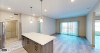 Located in Naples, FL, this thoughtfully designed 3-bedroom, 2-bathroom residence offers a clean, modern aesthetic throughout its single-floor layout. The open-concept kitchen and living area serves as the heart of the home, featuring a large center island with a crisp white countertop, dark wood-grain cabinetry, a white subway tile backsplash, and a full suite of stainless steel appliances including a refrigerator with ice maker, electric range, microwave, and dishwasher. Pendant lighting above the island adds a contemporary touch. Light wood-style flooring flows seamlessly throughout the living areas, complementing the neutral warm-beige wall palette and creating a bright, cohesive feel. The living room opens to a balcony through full-length sliding glass doors dressed with vertical blinds, filling the space with natural light. Each of the three bedrooms is well-proportioned, with the spacious primary bedroom offering ample room for furnishings. Ceiling fans with lighting are featured in the bedrooms, and windows with blinds provide natural light and privacy. The bathrooms are finished with tile flooring, tiled tub-shower surrounds, modern vanities, and recessed lighting. A dedicated laundry area houses a full-size top-loading washer and dryer with overhead shelving. Three closets provide generous storage throughout the home.