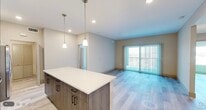 Located in Naples, FL, this thoughtfully designed 3-bedroom, 2-bathroom residence offers a clean, modern aesthetic throughout its single-floor layout. The open-concept kitchen and living area serves as the heart of the home, featuring a large center island with a crisp white countertop, dark wood-grain cabinetry, a white subway tile backsplash, and a full suite of stainless steel appliances including a refrigerator with ice maker, electric range, microwave, and dishwasher. Pendant lighting above the island adds a contemporary touch. Light wood-style flooring flows seamlessly throughout the living areas, complementing the neutral warm-beige wall palette and creating a bright, cohesive feel. The living room opens to a balcony through full-length sliding glass doors dressed with vertical blinds, filling the space with natural light. Each of the three bedrooms is well-proportioned, with the spacious primary bedroom offering ample room for furnishings. Ceiling fans with lighting are featured in the bedrooms, and windows with blinds provide natural light and privacy. The bathrooms are finished with tile flooring, tiled tub-shower surrounds, modern vanities, and recessed lighting. A dedicated laundry area houses a full-size top-loading washer and dryer with overhead shelving. Three closets provide generous storage throughout the home.