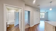 Located at 501 W Waugh St in Dalton, Georgia, this single-story, one-bedroom, one-bathroom residence offers a thoughtfully designed layout with modern finishes throughout. The kitchen serves as a central highlight, featuring warm wood-toned cabinetry, a subway tile backsplash, stainless steel appliances including a refrigerator, range, and built-in microwave, and a granite-topped island with pendant lighting and an undermount sink — ideal for both meal prep and casual dining. Hardwood-style flooring runs through the kitchen and main living areas, while plush carpet adds comfort to the bedroom and living room. The generously sized primary bedroom provides ample room to furnish and includes a dedicated closet outfitted with multi-tiered wire shelving for organized storage. The full bathroom is finished with a granite vanity with an undermount sink, wood-toned cabinetry, and a tub/shower combination surrounded by classic white subway tile. Throughout the space, neutral gray walls, clean white trim, recessed lighting, and a crisp, modern aesthetic create a bright and cohesive ambiance. A window in the living area allows for natural light, enhancing the open feel of this efficiently designed residence.