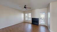 Located in El Paso, TX (79912), this single-story, 2-bedroom, 4-bathroom home offers a well-organized layout designed for comfortable everyday living. The living room serves as the heart of the home, featuring rich hardwood-style flooring, a ceiling fan, and a striking black-tiled wood-burning fireplace flanked by windows that invite natural light. A glass door provides direct outdoor access, enhancing the open feel of the space. The kitchen is equipped with warm honey-toned cabinetry, dark countertops, black appliances including a range, refrigerator, and dishwasher, and a skylight that brightens the room naturally. Light wood-style flooring ties the kitchen seamlessly to the adjoining dining area. A central hallway connects the main living spaces to the bedrooms, with louvered doors leading to closets and additional rooms. The spacious primary bedroom features plush carpeting, large windows with outdoor views, and a generous walk-in closet with dual hanging rods. The secondary bedroom is equally well-appointed with soft carpeting. Four bathrooms provide ample convenience, with at least one featuring a tub-shower combo. A dedicated laundry room and four closets throughout round out this practical and comfortable home.