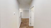 Located at 1000 Lakeridge Rd in Hampton, Virginia, this single-floor residence offers a well-organized layout with a neutral color palette of warm beige and white tones throughout. Wood-look flooring runs through the main living areas and hallways, providing a cohesive and easy-to-maintain surface.

The kitchen is a functional centerpiece, featuring white shaker-style cabinetry, granite countertops, a double undermount sink with a brushed nickel faucet, and a full suite of stainless steel appliances including a refrigerator, range, microwave, and dishwasher. A chandelier illuminates the adjacent dining area, which connects seamlessly to the rest of the living space.

The living area is bright and open, highlighted by French doors that allow natural light to filter in and provide outdoor access. A ceiling fan adds comfort overhead, while textured ceilings add subtle architectural character throughout.

Bedrooms feature plush carpeting and generous closet space, including a walk-in closet with mirrored sliding doors in one room. The bathroom includes a white vanity with granite countertops, a large mirror, and a bathtub. A dedicated laundry room houses a full-size washer and dryer alongside utility shelving and the electrical panel.