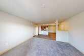 Located in Snoqualmie, WA, this single-floor, three-bedroom, two-bathroom residence offers a well-designed open-concept layout. The kitchen is a standout feature, equipped with stainless steel appliances including a refrigerator, gas range, and microwave, complemented by rich dark-brown cabinetry, light countertops, and a peninsula with a sink that seamlessly connects to the dining and living areas. The living room is generously proportioned, featuring durable wood-style flooring that transitions to plush carpeting, creating a warm and comfortable atmosphere. A private balcony accessible from the living area brings in natural light and outdoor views. The three bedrooms are carpeted and well-sized, with the primary bedroom offering ample space. Abundant storage is provided throughout, with five closets including walk-in options fitted with wire shelving systems. The two bathrooms feature wood-toned cabinetry, light countertops, and tile-style flooring, with at least one including a full soaking tub. A dedicated in-unit laundry area adds everyday convenience. Neutral tones and clean finishes throughout create a bright, move-in-ready environment suited for comfortable living in the Pacific Northwest.