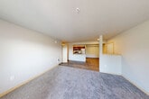Located in Snoqualmie, WA, this single-floor, three-bedroom, two-bathroom residence offers a well-designed open-concept layout. The kitchen is a standout feature, equipped with stainless steel appliances including a refrigerator, gas range, and microwave, complemented by rich dark-brown cabinetry, light countertops, and a peninsula with a sink that seamlessly connects to the dining and living areas. The living room is generously proportioned, featuring durable wood-style flooring that transitions to plush carpeting, creating a warm and comfortable atmosphere. A private balcony accessible from the living area brings in natural light and outdoor views. The three bedrooms are carpeted and well-sized, with the primary bedroom offering ample space. Abundant storage is provided throughout, with five closets including walk-in options fitted with wire shelving systems. The two bathrooms feature wood-toned cabinetry, light countertops, and tile-style flooring, with at least one including a full soaking tub. A dedicated in-unit laundry area adds everyday convenience. Neutral tones and clean finishes throughout create a bright, move-in-ready environment suited for comfortable living in the Pacific Northwest.