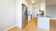 Located at 746 Midland Avenue in Toronto's Scarborough district, this well-appointed one-bedroom, one-bathroom unit offers a clean and functional layout across a single floor. Light-toned hardwood flooring runs consistently throughout the space, creating a warm, cohesive feel.

The open-concept kitchen and living area forms the heart of the unit. The kitchen features white cabinetry, a stainless steel refrigerator, a stove, and a countertop with ample workspace. A partial dividing wall separates the kitchen from the living area while maintaining an airy, connected feel. Natural light flows in through large windows, offering views of the surrounding neighbourhood.

The living area is generously proportioned, with soft grey walls and a wall-mounted climate control unit. A radiator beneath the windows provides additional heating comfort.

The bedroom is a well-sized retreat, also finished with hardwood flooring and neutral grey walls. It includes a built-in sliding door closet for storage and benefits from a window with natural light. A radiator unit is also present.

The bathroom is clean and bright, featuring white subway tile surrounding a full soaking bathtub, complemented by a white vanity with a grey countertop. The overall aesthetic throughout is modern, minimal, and move-in ready.