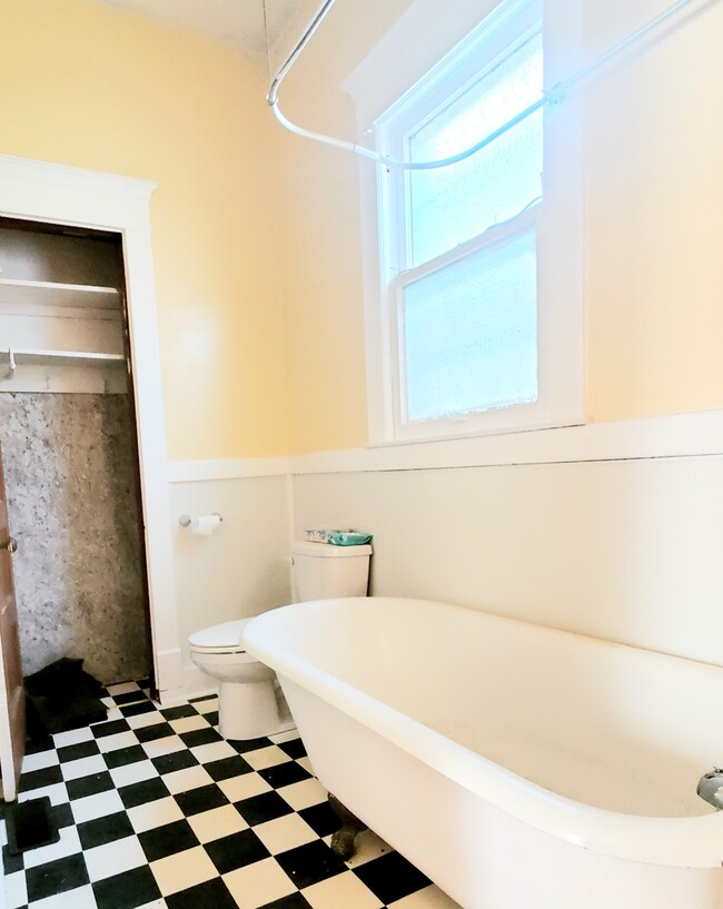 Bathroom with 2 linen closets. Clawfoot tub with shower. - 2313 W Oak St