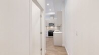 Located at 2515 Hackett Crescent in Saanichton, BC, this thoughtfully designed three-bedroom, two-bathroom residence offers a bright and modern living experience on a single floor. The open-concept kitchen and living area serves as the heart of the home, showcasing sleek flat-panel cabinetry in soft grey tones, a crisp white quartz island, and a full suite of stainless steel appliances including a gas range, built-in microwave, refrigerator, and dishwasher. A subtle tile backsplash and recessed lighting complete the polished kitchen aesthetic. Light-toned laminate flooring runs throughout the main living areas, complementing the clean white walls and creating a cohesive, airy atmosphere. Large windows in the living and bedroom areas invite generous natural light and offer views of the surrounding landscaped courtyard and community. Each bedroom is well-proportioned with ample natural light, while the primary bedroom provides a comfortable and private retreat. Both bathrooms are finished in a consistent modern style, featuring large-format tile flooring, white soaker tub-shower combinations, and contemporary vanities with integrated sinks. A hallway connects the spaces efficiently. The outdoor patio area features stone pavers and greenery, extending the living experience beyond the interior.