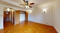 Located in the heart of Chicago's desirable Lincoln Park neighborhood, this well-appointed one-bedroom, two-bathroom residence offers a thoughtfully designed layout across a single floor. The spacious primary bedroom is the centerpiece of the home, featuring warm parquet hardwood flooring laid in an eye-catching basketweave pattern, a ceiling fan with integrated lighting, wall sconces, a generous closet with classic wood-trimmed doors, and a window framing urban skyline views with a cast-iron radiator below. The hallway connects the rooms seamlessly and is lined with a built-in multi-drawer dresser for ample storage. White subway tile walls lend a clean, classic aesthetic throughout the corridor. Both bathrooms continue the timeless design with white square wall tiles, black-and-white mosaic tile flooring, wood-framed mirrors, and pedestal sinks. One bathroom includes a glass-enclosed shower. The compact kitchen is efficiently outfitted with rich wood cabinetry, granite countertops, white subway tile backsplash, and a full suite of stainless steel appliances including a gas range, over-the-range microwave, and refrigerator. The decorative ceiling tile in the hallway and arched doorway details add architectural character throughout this classic Chicago residence.