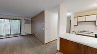 Located at 205 Fifth Ave E in Sartell, MN, this two-bedroom, one-bathroom unit offers a well-organized single-floor layout. The living room is comfortably sized with plush carpeting, a textured ceiling, and a full-width sliding glass door fitted with vertical blinds that fills the space with natural light and provides a view of the surrounding greenery. A wall-mounted air conditioning unit and baseboard heating ensure year-round comfort.

The galley-style kitchen is efficiently designed with ample upper and lower cabinetry featuring warm wood accents, a dual-basin sink, white appliances including an electric range and refrigerator, and tile flooring that adds a clean, functional finish. A peninsula counter separates the kitchen from the main living area.

Both bedrooms are carpeted and feature windows overlooking the tree-lined surroundings, textured ceilings, and baseboard heating. The primary bedroom offers generous floor space and a dedicated closet with dual shelving on either side. The second bedroom provides a comfortable and well-lit retreat.

The full bathroom includes a tub-shower combination, a single-sink vanity with wood cabinetry, a large mirror, and tile flooring, maintaining the unit's clean and neutral aesthetic throughout. A hallway connects all rooms, making for a logical and easy-to-navigate floor plan.