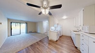 Located at 1167 Saint Matthew Place in Concord, CA, this two-bedroom, one-bathroom residence offers a practical and comfortable single-floor layout. The open-concept kitchen and living room form the heart of the home, where wood-style flooring runs underfoot and a ceiling fan with light fixture overhead provides both comfort and illumination. The kitchen is outfitted with white cabinetry, ample counter space, a white appliance suite including a range, dishwasher, refrigerator, and built-in microwave, making it functional and efficient. The living room transitions seamlessly from the kitchen and features a sliding glass door that opens to a private balcony overlooking lush, green surroundings, bringing natural light and outdoor views into the space. Both bedrooms are carpeted and bright, each featuring windows with vertical blinds that filter natural light. The primary bedroom offers generous proportions and includes its own sliding door access to the balcony. The full bathroom is clean and well-appointed, featuring a tub-shower combination with marble-style surround, wood-style flooring, and a vanity with storage. Additional closets and a connecting hallway complete this well-organized, move-in-ready home.