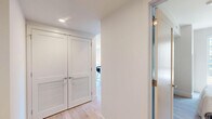 Located at 1201 Callowhill St in Philadelphia's vibrant Callowhill neighborhood, this 2-bedroom, 2-bathroom unit offers a thoughtfully designed single-floor layout with a clean, contemporary aesthetic. Light wood flooring and a neutral color palette flow seamlessly throughout, creating a bright and cohesive atmosphere.

The open-concept kitchen is a standout feature, outfitted with white flat-panel cabinetry, warm wood accents, a white quartz waterfall island with seating for three, stainless steel appliances, subway tile backsplash, and pendant lighting. The adjacent living room benefits from multiple large windows that frame views of the surrounding Philadelphia streetscape, flooding the space with natural light.

Both bedrooms are well-proportioned and serene, featuring large windows with urban views, light wood flooring, and soft neutral walls. The primary bedroom receives ample natural light from a street-facing window, providing a calm and restful retreat.

Each bathroom is finished with floating wood-toned vanities, backlit mirrors, and light wood-look flooring. One bathroom features a glass-enclosed walk-in shower with large-format tile, while the second includes a tub-shower combination. A connecting hallway links the rooms efficiently, completing the functional and modern layout of this Philadelphia residence.