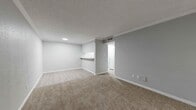 This two-bedroom, one-bathroom unit in Webster, Texas offers a practical and comfortable single-story layout. The open living room greets you at the entry, featuring plush carpeted flooring, soft gray walls, crown molding, and a textured ceiling. Natural light filters in through a large window with blinds beside the front door, creating a bright and welcoming atmosphere. A pass-through counter connects the living area to the kitchen, which is equipped with granite-style countertops, white cabinetry with sleek hardware, light wood-style flooring, and a stainless steel refrigerator. The primary bedroom is a generously sized retreat with a ceiling fan, carpeted floors, and a window that brings in natural light. The second bedroom also features carpet, a ceiling fan, and a window, offering comfortable proportions for a variety of uses. Both bedrooms are served by a shared full bathroom finished with light wood-style flooring, a vanity with granite-style countertops, and a tiled tub-shower combination. A hallway and closet provide additional storage and circulation. The unit also includes a dedicated closet to meet everyday storage needs. Consistent gray tones, white trim, and textured ceilings tie the space together with a cohesive, clean aesthetic throughout.