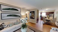 Located at 2355 Michigan Ave in Pensacola, Florida, this single-floor residence offers a thoughtfully designed open-concept layout that seamlessly connects the main living areas. The living room serves as a welcoming centerpiece, featuring warm hardwood flooring, neutral-toned walls, and ample space for comfortable furnishings. Decorative wall art adds a stylish, curated touch to the space, complemented by natural light that enhances the bright and airy atmosphere throughout. The open flow leads directly into the dining and kitchen areas, where rich dark cabinetry contrasts beautifully with light countertops and stainless steel appliances. The kitchen is well-equipped and practical, with a window that allows natural light to fill the space. The dining area sits adjacent to the kitchen, offering a convenient and connected space for everyday meals. Consistent hardwood-style flooring runs throughout the main living areas, tying the rooms together cohesively. The overall ambiance of the home is clean, modern, and inviting, with a neutral color palette that provides a versatile backdrop for a variety of interior styles. This single-level layout ensures easy accessibility and a comfortable flow between all areas of the home.