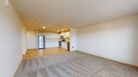 Located in Everett, Washington, this well-appointed 4-bedroom, 2-bathroom unit offers a thoughtfully designed single-level layout with a generous amount of living space. The open-concept kitchen and living area creates a welcoming, airy atmosphere, with the kitchen featuring crisp white cabinetry, ample counter space, stainless steel appliances including a refrigerator, range, microwave, and dishwasher, all set atop easy-care hardwood-style flooring. The expansive living area transitions seamlessly from the kitchen and is finished with plush wall-to-wall carpeting, providing a comfortable and versatile space. A door leads out to a private balcony, where sweeping outdoor views fill the space with natural light. Each of the four bedrooms is carpeted and well-sized, with windows that frame pleasant exterior views, creating bright and inviting retreats. The primary bedroom includes a spacious walk-in closet outfitted with wire shelving for organized storage. Both bathrooms are finished with light wood-style flooring, white vanities with ample cabinetry, and clean, functional fixtures. A hallway connects the living spaces to the bedrooms, ensuring a practical and efficient flow throughout the unit.
