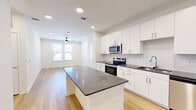 Located at 1609 W Chapman Dr in Sanger, TX, this single-story, 2-bedroom, 2-bathroom home offers a clean, modern aesthetic throughout. Light wood flooring flows seamlessly across the entire living space, complementing the crisp white walls and creating a bright, cohesive interior.

The kitchen serves as a focal point of the home, featuring white shaker-style cabinetry, dark granite countertops, a classic subway tile backsplash, and a full suite of stainless steel appliances including a range, microwave, dishwasher, and refrigerator. A central island with matching granite provides additional workspace and casual seating. Recessed lighting illuminates the open-concept kitchen and living area.

Both bedrooms are well-proportioned with natural light provided by windows fitted with horizontal blinds. The primary bedroom is a comfortable size and is served by a dedicated walk-in closet featuring multi-level shelving and hanging rods. A second walk-in closet serves the additional bedroom.

Each of the two bathrooms is finished with consistent design details, including white subway tile tub-and-shower surrounds, granite-topped vanities, and wood-look flooring. The overall design of the home is clean, contemporary, and move-in ready, offering functional layouts and quality finishes throughout.