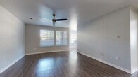 Located at 9103 Renner Blvd in Lenexa, Kansas, this single-floor, one-bedroom, one-bathroom home offers a well-designed layout that maximizes every inch of its living space. The open-concept living room and kitchen area serves as the heart of the home, featuring rich, dark hardwood-style flooring that flows throughout the main living areas. Multiple windows dressed with white blinds allow generous natural light to fill the space, complemented by a ceiling fan that adds both function and character.

The galley-style kitchen is thoughtfully equipped with white cabinetry, granite-style countertops, and black appliances including a range, refrigerator, dishwasher, and over-the-range microwave. Light hardwood-style flooring in the kitchen and dining nook creates a warm, cohesive feel, with a window overlooking the outdoors providing a bright backdrop.

The bedroom offers plush carpeting underfoot, a ceiling fan, a dedicated closet, and a window that brings in natural light, creating a comfortable and restful retreat. The bathroom features a full tub-shower combination with clean white surrounds and wood-style flooring, maintaining the home's consistent, modern aesthetic throughout. Two hallways connect the spaces efficiently, completing this well-organized and move-in-ready home.