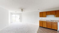 Located at 4305 W Washington St in Springfield, Illinois, this single-floor unit offers a practical and comfortable layout designed for everyday living. The open living area is finished with plush wall-to-wall carpeting and features a ceiling fan overhead, along with a sliding glass door that fills the space with natural light and provides direct access to an outdoor patio overlooking a grassy landscape. Adjacent to the living area, the kitchen is equipped with warm honey-toned wood cabinetry spanning both upper and lower sections, a clean countertop workspace, a double sink, and white appliances including a refrigerator, electric range, and dishwasher. Durable wood-look flooring runs throughout the kitchen, creating a clean transition between spaces. The bedrooms are carpeted and bright, with neutral walls and windows that invite natural light. One bedroom features a sliding glass door offering additional outdoor access and views. The full bathroom includes a wood-toned vanity with storage, a mirrored medicine cabinet with overhead lighting, and a shower-tub combination, all finished with easy-care hard surface flooring. Throughout, the unit maintains a clean, neutral palette that provides a versatile foundation for a variety of living arrangements.