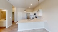 Located at 900 3rd St SE in Cedar Rapids, Iowa, this one-bedroom, one-bathroom residence offers a thoughtfully designed layout with modern finishes throughout. The open-concept kitchen is a standout feature, showcasing crisp white shaker cabinetry, light quartz countertops, a large peninsula with an undermount sink, stainless steel appliances including a refrigerator, range, built-in microwave, and dishwasher, and stylish brushed gold pendant lighting overhead. Light wood-tone flooring runs through the kitchen and main living areas, creating a warm and cohesive aesthetic. The living room benefits from large windows that invite abundant natural light and offer views of the surrounding Cedar Rapids cityscape, complemented by a ceiling fan for added comfort. The bedroom features plush carpeting, elevated ceilings with a visible HVAC vent, and a spacious closet with built-in shelving, along with access to an additional nook area ideal for a desk or workspace. The bathroom is finished with wood-look flooring, a full soaking tub and shower combo with brushed nickel fixtures, and a clean white vanity. A stacked in-unit washer and dryer is also included, adding everyday convenience to this well-rounded, modern residence.