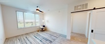 This contemporary 1060 square foot apartment in Denver offers a harmonious blend of style and functionality. The heart of the home is a striking kitchen, featuring a two-tone color scheme with crisp white upper cabinets and eye-catching blue lower cabinets. Stainless steel appliances, including a side-by-side refrigerator and built-in microwave, complement the modern aesthetic. A generous island with a white countertop provides additional workspace and casual seating.

The living area boasts light wood flooring and large windows that flood the space with natural light. A modern ceiling fan adds both style and comfort. The primary bedroom, measuring 170 square feet, ensures ample space for relaxation. Both bathrooms showcase a clean, modern design with hexagonal floor tiles, white fixtures, and sleek hardware.

Storage solutions are plentiful, with two closets featuring adjustable shelving and hanging rods. The apartment's neutral color palette, predominantly whites and light grays, creates a bright, airy atmosphere throughout. This well-designed space offers a perfect balance of comfort and contemporary living in the heart of Denver.