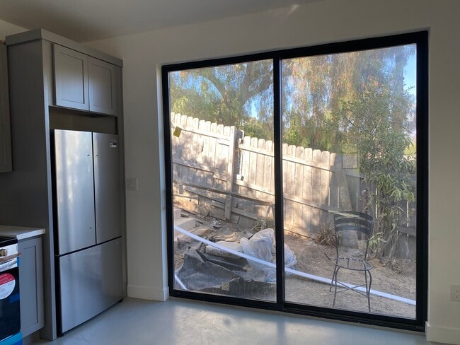 Las puertas corredizas de la sala de estar conducen al patio de ladrillo y a los escalones que suben a la azotea. - 4435 Radium Dr