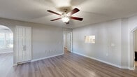 Located at 2410 Allerton Way in Charlotte, NC, this single-story, 3-bedroom, 2-bathroom home offers a practical and comfortable layout with consistent, neutral finishes throughout. Wood-look laminate flooring runs through the living areas and bedrooms, complemented by light gray walls, white trim, and textured ceilings that lend a classic residential feel.

The home features two living areas, both equipped with ceiling fans and a pass-through window connecting to the kitchen area, providing a sense of openness between the spaces. Natural light enters through multiple windows fitted with blinds, brightening the living rooms and bedrooms alike. A dedicated dining room adds to the home's functional layout.

Each of the three bedrooms offers a comfortable footprint, with the primary bedroom providing generous space and closet access. The home includes five closets in total, ensuring ample storage throughout. Both bathrooms are fitted with tub-shower combinations featuring curved curtain rods and chrome fixtures.

A dedicated laundry room houses a full-size washer and dryer with overhead shelving, adding everyday convenience. A pantry rounds out the kitchen utility. The straightforward, single-floor plan connects all rooms via a central hallway, making the layout easy to navigate and well-suited for a variety of lifestyles.