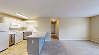 Located at 3691 Clay Pond Rd in Myrtle Beach, SC, this single-floor, 2-bedroom, 2-bathroom home offers a practical and comfortable layout. The heart of the home is an open-concept space that seamlessly combines the living room, dining area, and kitchen. The kitchen is well-equipped with white upper cabinetry, gray lower cabinets, a double sink, white appliances including a refrigerator, range, and dishwasher, and a peninsula that provides additional counter space and separates the kitchen from the carpeted living area. Neutral tile-style flooring runs throughout the kitchen for easy maintenance. A hallway connects the main living space to the two carpeted bedrooms, each featuring natural light from window blinds and ceiling fans. The spacious primary bedroom includes direct access to a private bathroom with a rich wood-toned vanity, framed mirror, and a tub-shower combination. The second bathroom mirrors the clean, functional aesthetic. Three closets provide ample storage throughout, while a dedicated laundry room and utility room add everyday convenience. Warm beige tones and textured ceilings carry throughout, creating a consistent and welcoming ambiance.