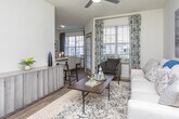 Located at 105 Oak Hill Dr in Athens, Georgia, this single-floor residence offers a thoughtfully designed layout with modern finishes and a cohesive, neutral aesthetic throughout. The galley-style kitchen is outfitted with white shaker cabinetry, granite countertops, subway tile backsplash, and stainless steel appliances, providing ample workspace and storage. Wood-style flooring runs through the main living and kitchen areas, adding warmth and continuity to the space. The living room is bright and welcoming, featuring a ceiling fan, large windows that invite natural light, and enough space to comfortably accommodate multiple seating arrangements. The bedrooms are carpeted for comfort, each offering ceiling fans, natural light from well-positioned windows, and closet access — including at least one walk-in closet. The bathrooms are finished with granite-topped vanities, white cabinetry with brushed nickel hardware, and tub-shower combinations with tile surrounds. Both bathrooms reflect a clean, contemporary design. Overall, the residence presents a polished, move-in-ready interior with consistent attention to detail, making it a functional and attractive living space in the Athens, GA community.
