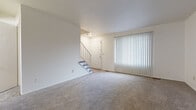 Located at 2005 Noe Bixby Rd in Columbus, Ohio, this two-floor home offers a straightforward and functional layout designed for comfortable everyday living. The main level welcomes you through a front entry door flanked by a large sliding glass door fitted with vertical blinds, allowing ample natural light to fill the spacious carpeted living area. A staircase leads to the upper level, connecting both floors seamlessly. The kitchen is well-equipped with white cabinetry, dark-toned countertops, wood-look vinyl flooring, and white appliances including a refrigerator, range, and dishwasher. A peninsula-style counter provides additional workspace and helps define the kitchen from the adjoining areas. Two bathrooms are present throughout the home, each featuring wood-look vinyl flooring and white vanities. The full bathroom includes a tub-shower combination with a window for natural ventilation. The upper level hosts multiple carpeted bedrooms, each with neutral white walls and windows fitted with blinds that bring in natural light. The consistent use of soft carpet in the living and bedroom spaces and durable vinyl flooring in wet areas reflects a practical and clean interior design throughout the home.