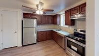 Located at 1 Hillside Ave in Rockaway, NJ, this single-floor residence offers four bedrooms and two bathrooms across a well-designed layout. The kitchen is a standout feature, outfitted with rich dark wood cabinetry, light stone countertops, a tile backsplash, and a full suite of stainless steel appliances including a refrigerator, dishwasher, and range. A ceiling fan with integrated lighting and durable wood-look flooring complete the space. The open living area is bright and airy, featuring light-toned hardwood-style flooring, dual flush-mount ceiling lights, and a baseboard heating system. The bedrooms are carpeted for comfort, with several offering generous closet space including sliding-door and built-in shelving closets, as well as windows that bring in natural light. One bedroom also includes a wall air conditioning unit. The two bathrooms are cleanly updated — one features a tiled tub-shower combination, a wood-toned vanity with under-cabinet storage, and a mirrored medicine cabinet, while the second offers a streamlined vanity with chrome fixtures and tile flooring. The floor plan provides a functional and comfortable living environment suitable for a variety of needs.