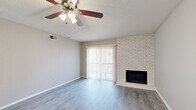 Located on Warwick Boulevard in Kansas City's Midtown neighborhood, this single-floor, two-bedroom, one-bathroom residence offers a well-organized layout across a comfortable footprint. The living room serves as the focal point of the home, featuring gray-toned hardwood-style flooring, a ceiling fan with light fixture, textured ceilings, and a striking white brick fireplace flanked by a sliding glass door that opens to a private balcony, allowing natural light to fill the space.

The kitchen is thoughtfully appointed with gray shaker-style cabinetry, granite countertops, a white subway tile backsplash, and a full suite of stainless steel appliances including a refrigerator, range, microwave, and dishwasher. Light wood-style flooring continues throughout, providing a cohesive aesthetic.

Both bedrooms are carpeted and include ceiling fans. The primary bedroom offers a window for natural light, while the secondary bedroom features a closet with bifold doors. A central hallway connects the bedrooms to the shared bathroom, which includes a tiled tub-and-shower surround, granite vanity countertop, and wood-style flooring, completing this clean, updated residence.